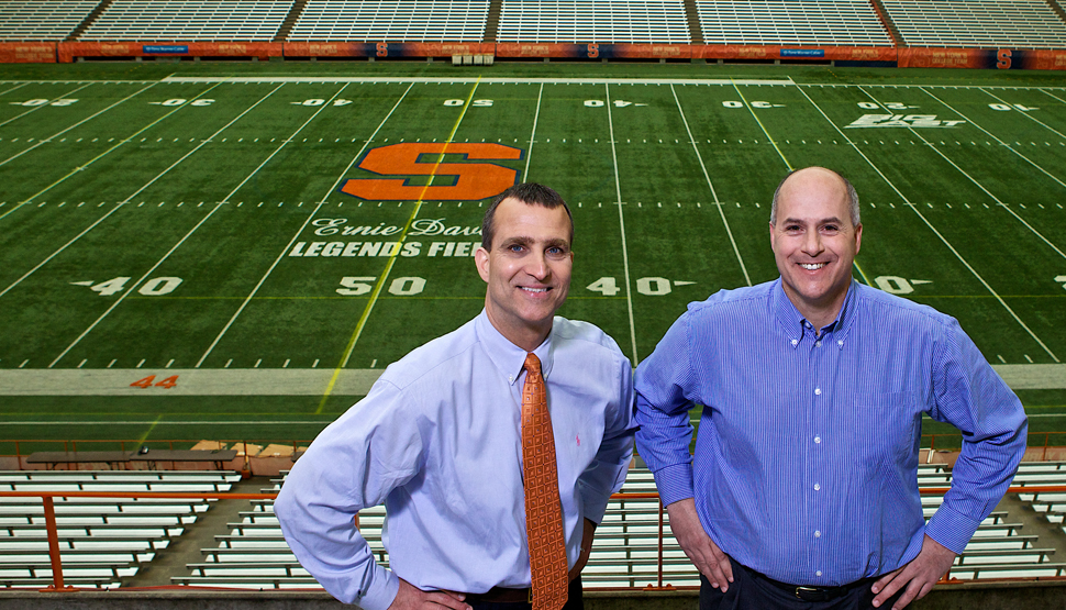 Syracuse University's Risk Management and Associate Athletic Director in front of a football field.